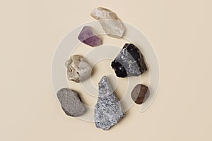 Different stones, precious and rocks on a beige background. Gemological concept. Study of minerals and bowels of the earth. photo