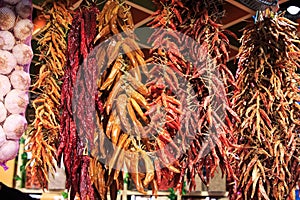 Different strips of hot peppers and chili peppers hanging from the ceiling in the Boqueria market