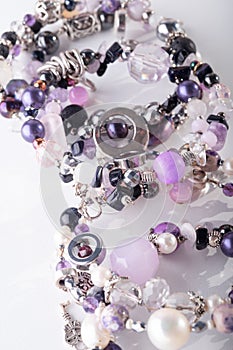 Different stylish jewelry bracelets with semiprecious  around  white background. hobby and fashion concept. close up photo