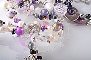 Different stylish jewelry bracelets with semiprecious  around  white background. hobby and fashion concept. close up photo