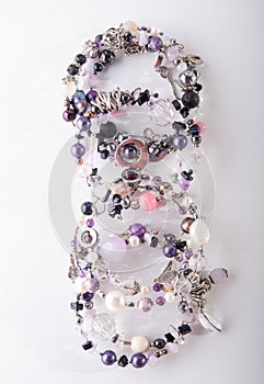 Different stylish jewelry bracelets with semiprecious  around  white background. hobby and fashion concept. top view photo