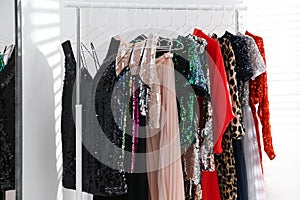 Different stylish women`s clothes on rack indoors