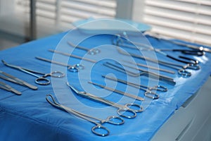 Different surgical instruments on blue table indoors