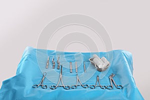 Different surgical instruments on table against light background