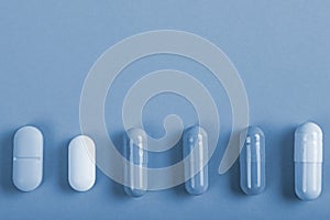 Different tablets capsules on tinted background