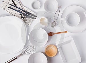 Different tableware and dishes on the white background, top view.