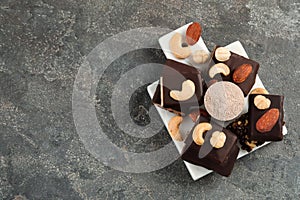 Different tasty energy bars, nuts and protein powder on grey table, top view. Space for text