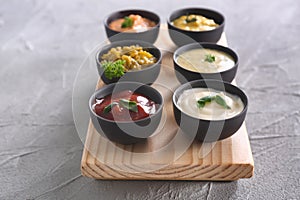 Different tasty sauces in bowls on wooden board photo