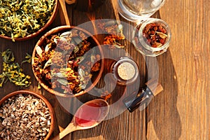 Different tinctures and ingredients on wooden table, flat lay