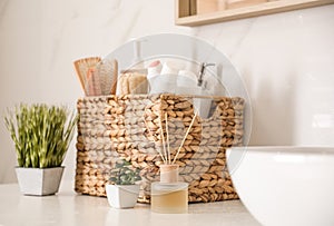 Different toiletries and green plants on countertop