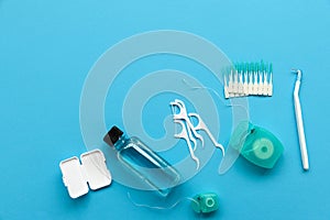 Different tools for dental care on blue background. Toothbrush, cleanser, floss, flossers, wax for braces and  interdental brush.