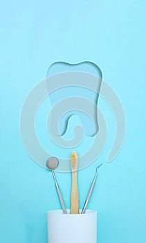 Different tools for dental care, toothbrush in plastic glass and molar tooth paper cut icon. Tooth symbol sign. Dental background