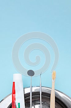 Different tools for dental care, toothbrush and toothpaste on blue Dental background. With copy space, close-up. Oral dental