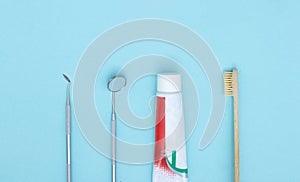 Different tools for dental care, toothbrush and toothpaste on blue Dental background. With copy space, close-up. Oral dental