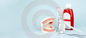 Different tools for dental care, toothbrush, toothpaste and Dental Teeth Model dentures on blue Dental background. With copy space