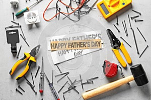 Different tools and papers with text Happy Father's Day on light background