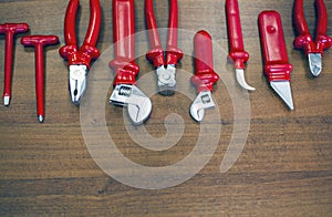 Different tools up to 1000 volts, for electromechanics, on a wooden background