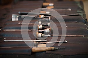 Gouges and chisels in the foreground leather case photo