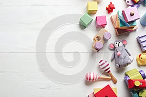 Different toys on white wooden background, flat lay. Space for text