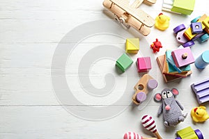 Different toys on white wooden background, flat lay. Space for text
