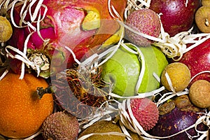 Different tropical fruits in gift box on wooden table. Different tropical fruits as background, closeup view photo