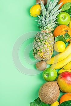 Different Tropical Summer Fruits. Pineapple Mango Coconut Citrus Oranges Lemons Apples Kiwi Bananas on Turquoise Background