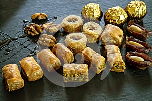 Different type of arabian sweets background baklava borma nest ush-el-bul-bul asabi dates and chocolate