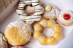Different type of donuts set, sweet donuts in a paper donut box dessert snack food. top view