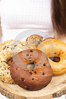 Different types of bagels on a wooden tray