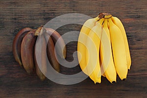 Different types of bananas on wooden table, flat lay