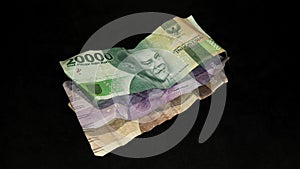 Different types of banknotes stacked on black background