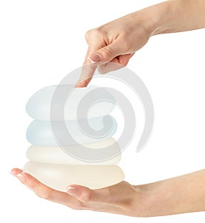 Different types of breast implants in hand on white background, clipping path.