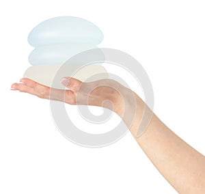 Different types of breast implants in hand on white background, clipping path.