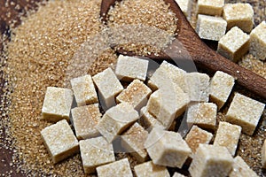 Different types of brown sugar with a wooden spoon.