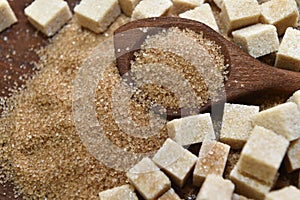 Different types of brown sugar with a wooden spoon.