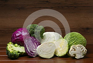 Different types of cabbage on wooden table