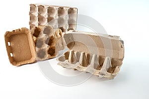 Different types of cardboard egg cartons arranged on a white background. Open, closed, and lidless designs showcase photo
