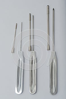 Different types of catheter trocars on grey surface