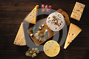 Different types of cheese on a cutting board top view