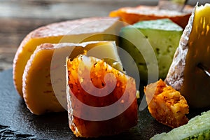 Different types of cheeses on black board. Food recipe background. Close up