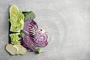 Different types of cut cabbage on light grey table, flat lay. Space for text