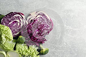 Different types of cut cabbage on light grey table, flat lay. Space for text
