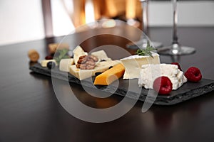 Different types of cheeses with berries and nuts on table
