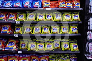 Different types of detergents on shelves in a supermarket. Tide is a laundry detergent manufactured by Procter & Gamble and one of