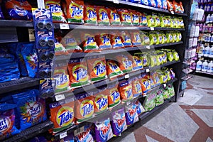Different types of detergents on shelves in a supermarket. Tide is a laundry detergent manufactured by Procter & Gamble and one of