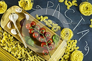 Different types of dried Italian pasta on a blue background. Top view