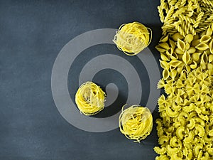 Different types of dry Italian pasta on a dark blue background.