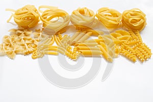 Different types of dry pasta on white