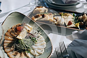 Different types of fish on a plate. Wedding table setting with food in restauran