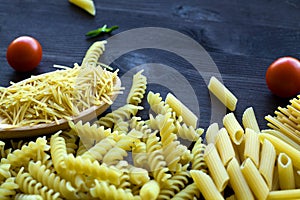 different types of Italian pasta with a wooden spoon on a table with copy space